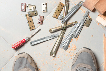 old tools and accessories of the carpenter's trade, on the ground and worker's feet
