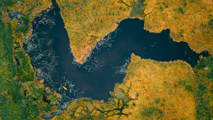 aerial top landscape view green,orance grassland and black lake small kayaking tourist activity relax at rayong botanical garden thailand