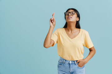 Young beautiful indian woman in glasses showing hope gesture