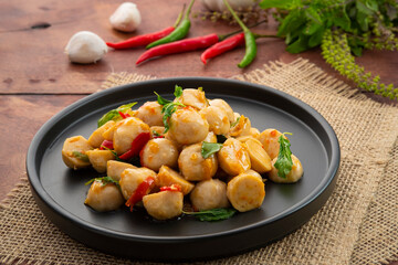 Stir-Fried pork meatballs with thai holy Basil on black plate