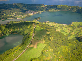 Beautiful volcanic mountain lakes of the Azores islands and surrounding lush green forests, fields and cliffs and the Atlantic ocean.