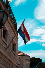 stone house facade with a hanging Croatia flag in Trogir, Croatia