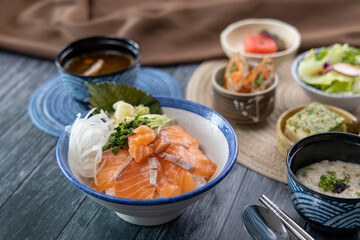 Salmon sashimi on rice and vegetable side dishes 