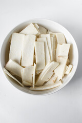 Raw yam in a white bowl, slices of raw yam, fried yam slices, nigerian white yam