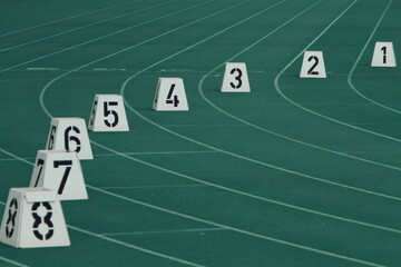 The curved lanes of a running track with a relay marker 21 May 2011