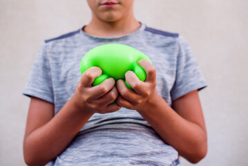 Teen boy playing with anti stress sensory ball squeeze toy. Giant stress balls are soft to the touch and help reduce stress and anxiety as you pull, squish, smash, squash, and grip them in all kinds 