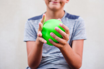 Teen boy playing with anti stress sensory ball squeeze toy. Giant stress balls are soft to the touch and help reduce stress and anxiety as you pull, squish, smash, squash, and grip them in all kinds 