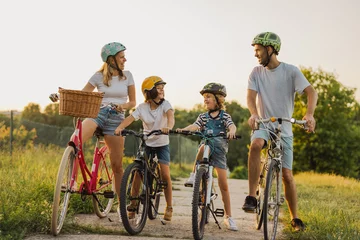 Poster Happy family cycling together in the countryside  © pikselstock