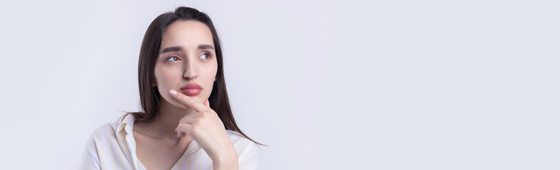 Naklejka premium Portrait of a beautiful young woman thinking, isolated on white background