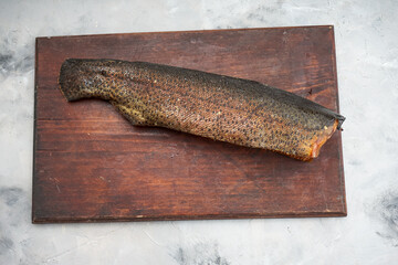 smoked zander fish on a wooden board on a light background
