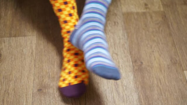 Men's legs and bright socks. Different socks as symbol of down syndrome. Down syndrome awareness concept.