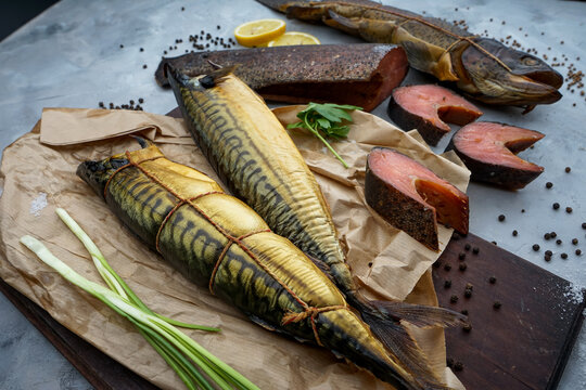 different types of hot smoked fish on a background with greens and spices macro photo

