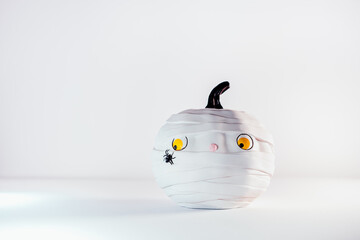 Funny and cute pumpkin mummy with spider on the white background. White Pumpkin with scaried and...