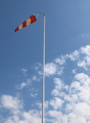 red and white windsock to indicate the direction - obrazy, fototapety, plakaty