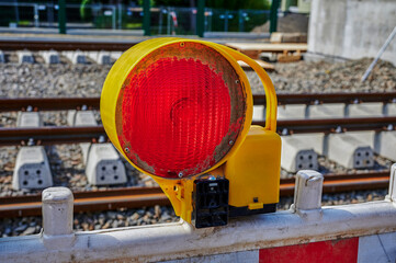 Warning light on a barrier in front of the construction site for a new railway line.