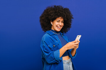 Cheerful young woman playing her favourite music on a smartphone