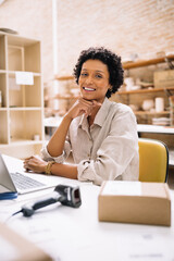 Cheerful young businesswoman smiling at the camera in a warehouse