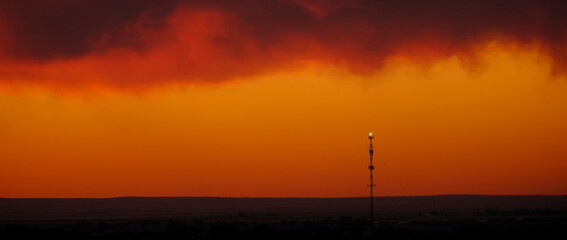 Naklejka premium Cell Tower for Digital Communication at Sunset Silhouette