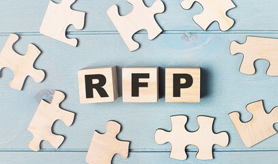Blank puzzles and wooden cubes with the text RFP Request for Proposal lie on a light blue...