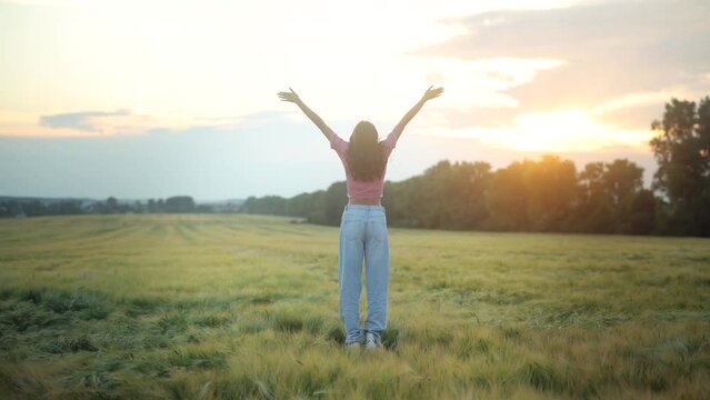 Beautiful woman in a field. Woman with arms outstretched in a field. Beauty girl enjoy with sun in the evening glow. Outdoor domestic travel relax in nature concept