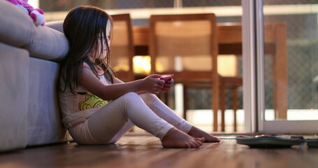 Little girl using smartphone device at night casual and candid