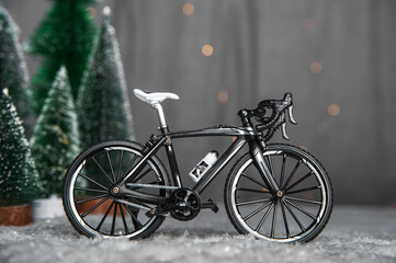 Miniature bike on background of Christmas trees and snow. Winter cycling