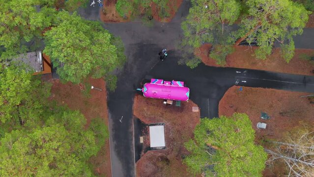 The drone flies over the park. Park with fast food restaurant. wagon with food in the park where people walk who can have a bite of delicious cooked food. Walking park with pink wagon with food.