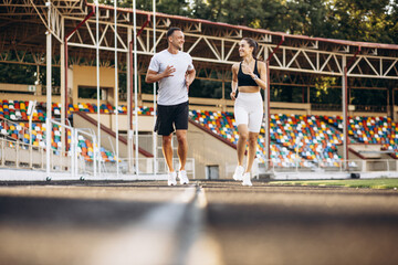 Couple running on the track at stadium