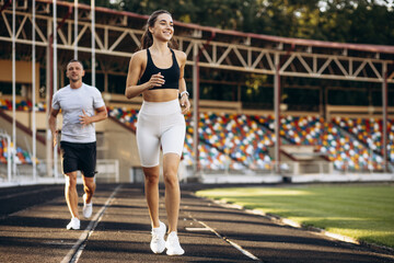Couple running on the track at stadium