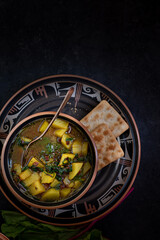 Fototapeta na wymiar Vegan beet greens and potato soup, dark background