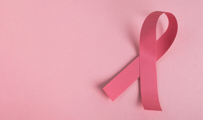 Pink breast cancer awareness ribbon on pastel background. Medicine and healthcare concept, women's...