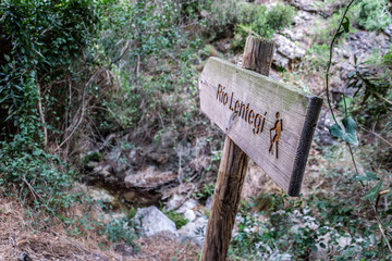 wooden sign indicating the way to the Lentegi river with a painted hiker