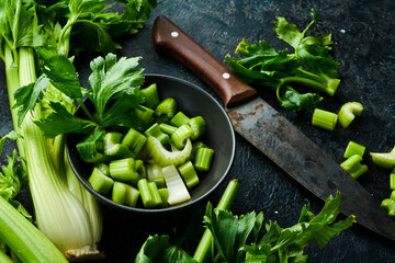 A stalk of fresh celery cut into pieces in a bowl. Dietary healthy food. Free space for text.