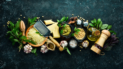 Pesto sauce. Ingredients for making pesto. On a black stone background. Top view.
