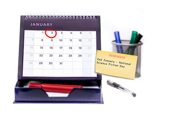 Red circle round date of 2nd January on a business desk diary with yellow reminder note with text of National Science Fiction Day.   Isolated on a white background