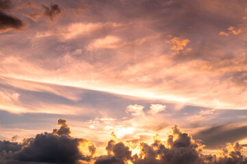 Obraz premium sunset / sun rise sky with rays of yellow and red light shining clouds and sky background and texture