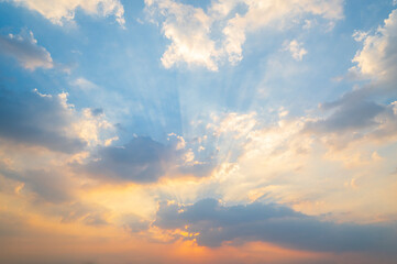 sunset / sun rise sky with rays of yellow and red light shining clouds and sky background and texture