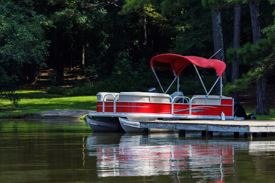 Pontoon boat at private dock on lake.