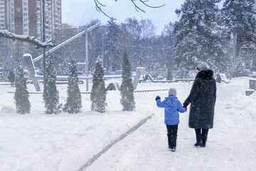 grandmother and grandson are walking around the snow-covered city, sightseeing. Family values