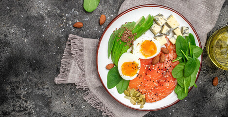 Keto diet food, salmon, avocado, cheese, egg, spinach and nuts. Ketogenic low carbs diet concept. Ingredients for healthy foods. Long banner format. top view