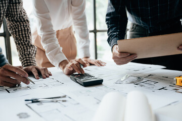 Close up of hands working brainstorming and measuring for cost estimating on paperworks and floor...