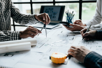 Close up of hands working brainstorming and measuring for cost estimating on paperworks and floor plan drawings about design architectural and engineering for houses and buildings.