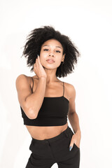 A young woman stylishly dressed model posing in a photo studio on a white background