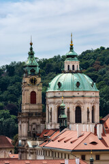 Towers with green domes of the Church of St. Nicholas in the Czech city of Prague.