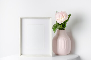 Frame mockup with pink peony flowers in vase, mockup for artwork presentation