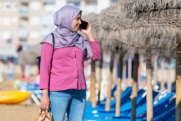 Serious looking muslim woman talking on her phone