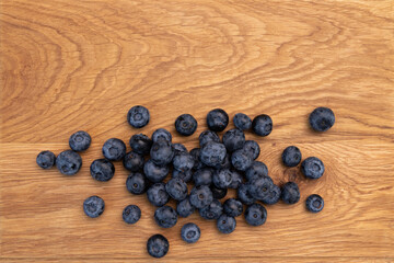 heap of ripe blueberries on wooden background