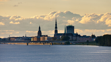Riga, in the photo panorama of the city gray clouds and sky in the background, river in the foreground