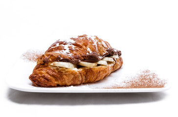 Croissant with chocolate butter and banana isolated on a white background.
