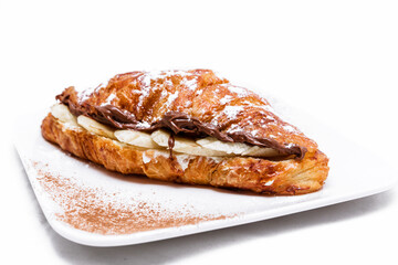 Croissant with chocolate butter and banana isolated on a white background.
